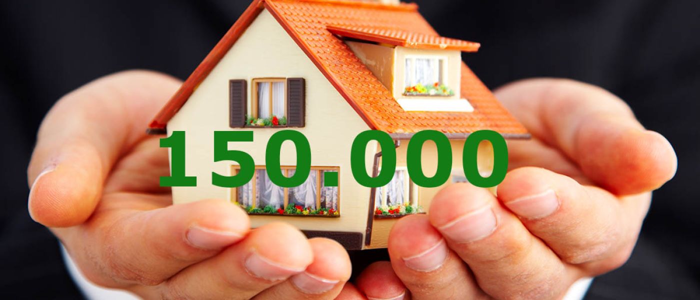 Ein paar Hände halten ein Spielzeughaus mit der Zahl 150000 - Kfw Zuschuss